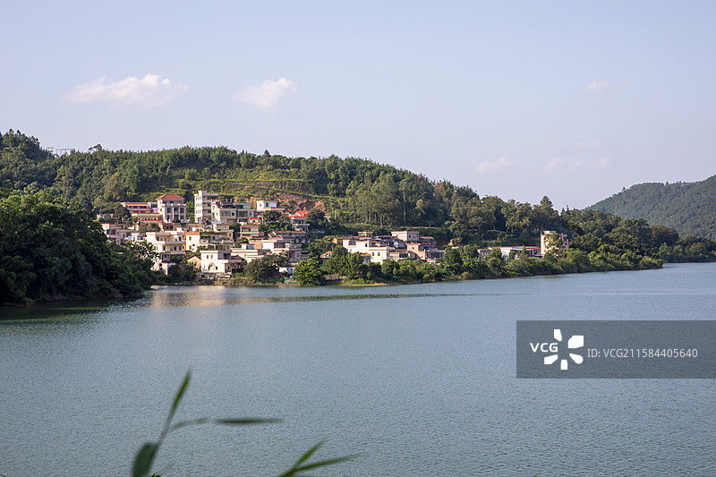 蓝天白云下的新兴共成水库，湖边上是自然山村图片素材