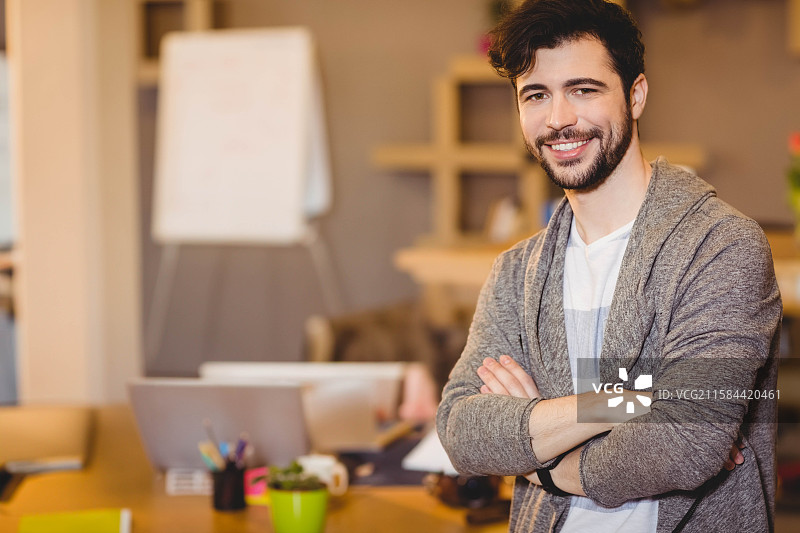 木桌上放着打开的笔记本电脑、冒着热气的咖啡杯、铅笔盒和多肉植物，旁边是翻转图表。图片素材