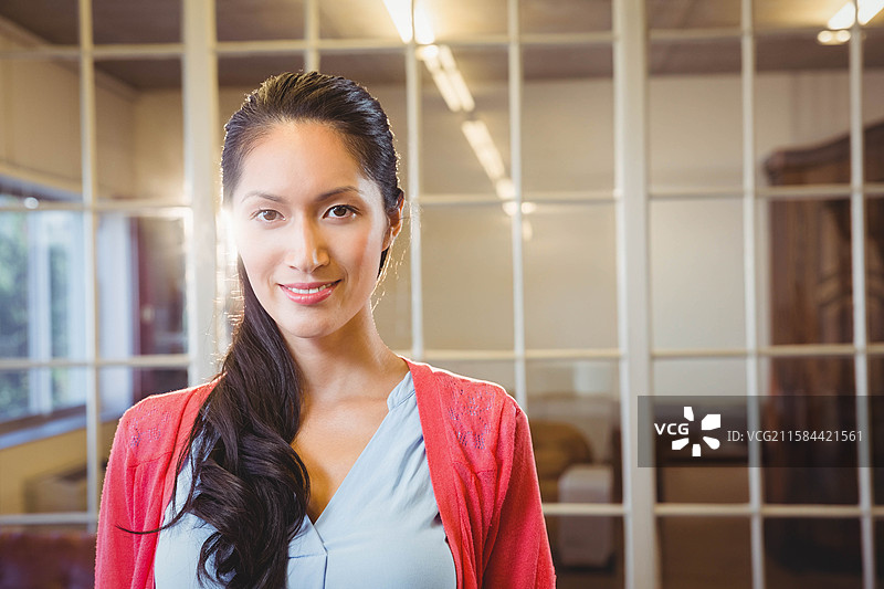 办公室休息区的玻璃隔断反射着顶部灯光和透过窗户洒入的日光图片素材