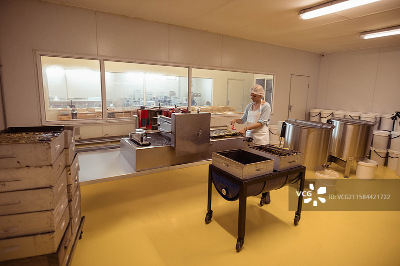 女性在食品加工室的不锈钢传送带上处理产品托盘，留有空白空间图片素材