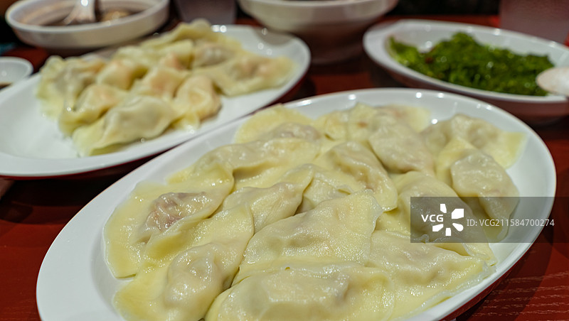 中国传统节日过年吃饺子拍摄主题，盘子装着一碗热腾腾的水饺，室内无人图像摄影图片素材