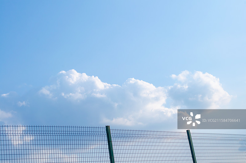 中国自然风光拍摄主题，白色的云彩和蓝色的天空，纹理效果的栅栏篱笆铁丝网，户外白昼无人图像摄影图片素材