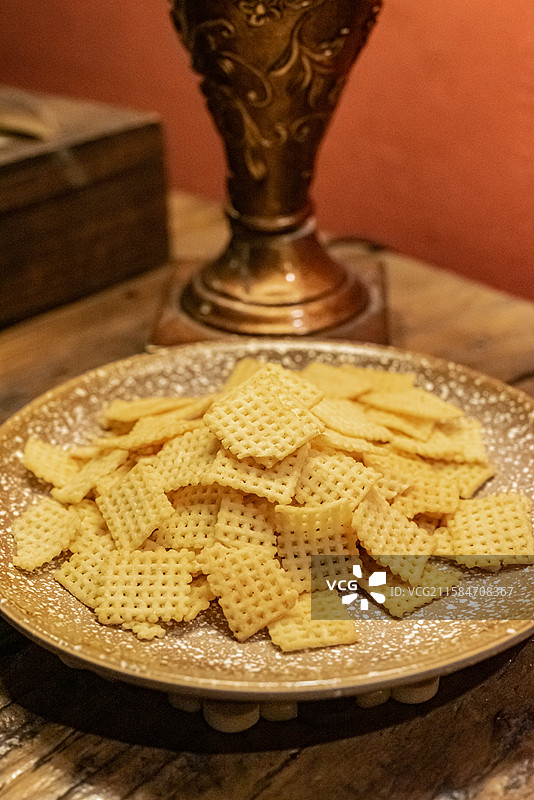 中国休闲娱乐健康生活方式拍摄主题，木制桌子上一堆黄色的锅巴小吃特写，室内无人图像摄影图片素材