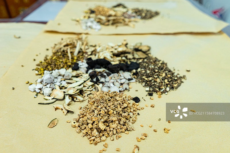 中国中医药服务拍摄主题，中医医院，黄色纸上放着一杆黄色铜制秤和一堆中草药，室内无人图像摄影图片素材