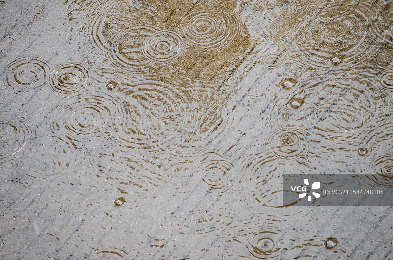 中国自然天气气候拍摄主题，下雨天雨水落在水泥地地面上溅起大量的水花，户外白昼无人图像摄影图片素材
