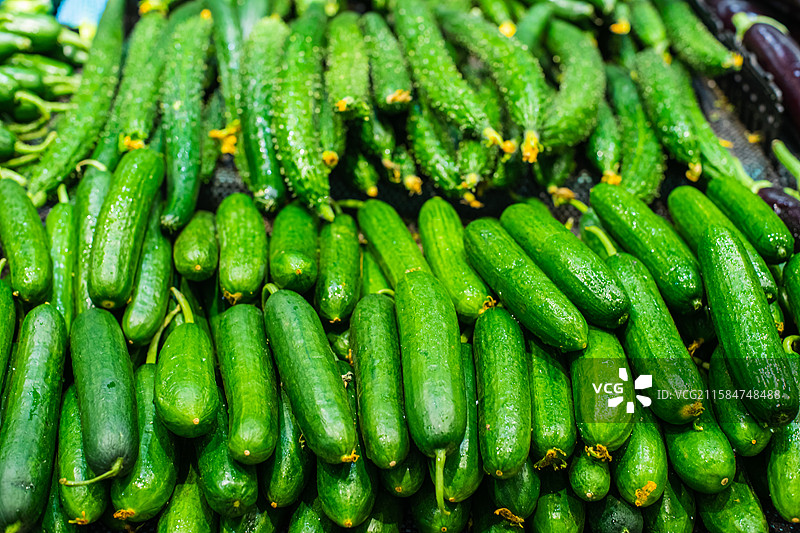 中国水果果蔬拍摄主题，超级市场零售货摊上一堆的绿色的黄瓜蔬菜产品，室内无人图像摄影图片素材