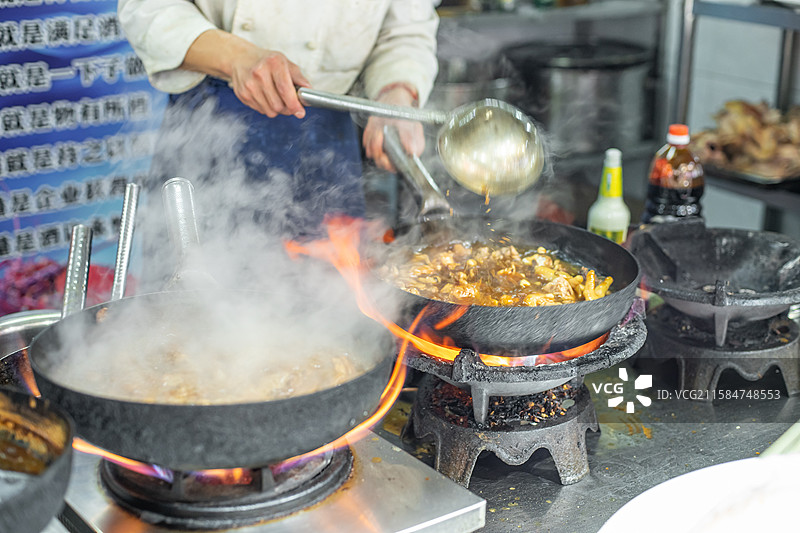 中国餐饮行业饮食产业，传统经典中国食品，美食拍摄主题，厨房里的厨师正在炉灶上炒菜，室内厨师图像图片素材