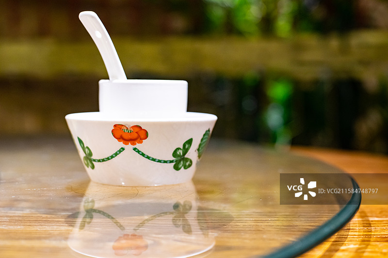 中国餐饮餐厅饭店饭馆行业，空的餐桌拍摄主题，中国传统木制圆桌上的叠起来的餐具，室内无人图像摄影图片素材