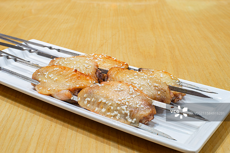 中国餐饮行业饮食产业美食拍摄主题，砂锅里的一盘子烧烤鸡翅美食特写，室内无人图像图片素材