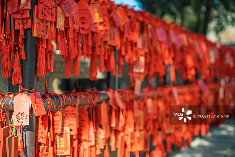 中国传统文化和自然风光拍摄主题  ,铁栏杆子上悬挂着大量红色许愿牌子，户外白昼无人图像摄影图片素材