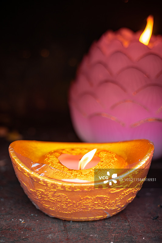 中国传统文化拍摄主题，一个金色的元宝蜡烛正在燃烧着，户外白昼无人图像摄影图片素材