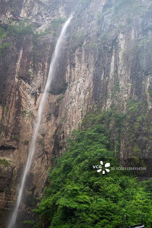浙江神仙居高山瀑布倾泻而下，绿树环绕图片素材