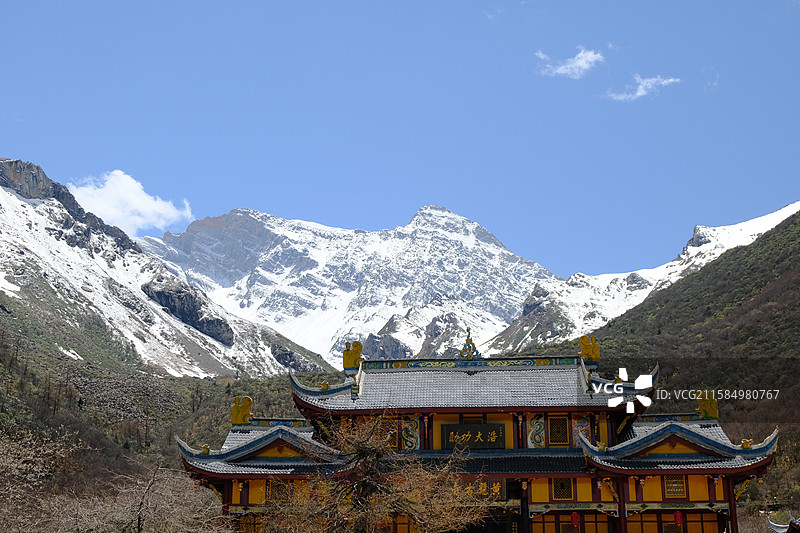 黄龙风景区白雪皑皑的群山映衬着蓝天白云下的黄龙古寺图片素材