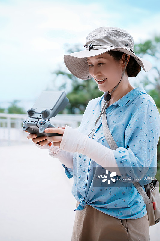 户外操作无人机控制器的女性图片素材