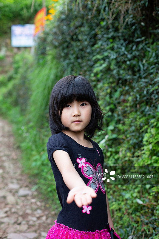 可爱的女孩站在植物旁图片素材