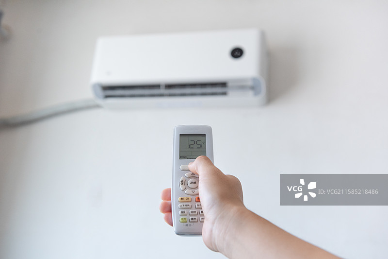手拿空调遥控器开空调特写图片素材