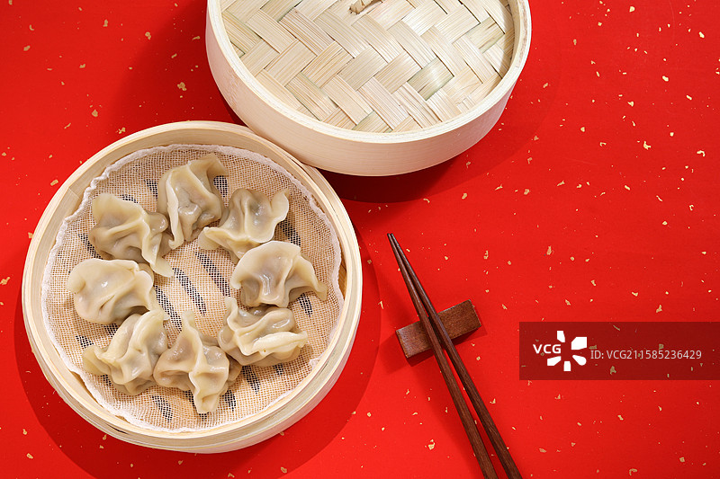红色桌面上的一蒸笼中国传统节日春节年夜饭美食饺子图片素材