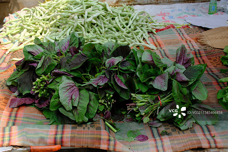 市场菜摊上的红苋菜。紫色有机蔬菜。豆角野菜图片素材