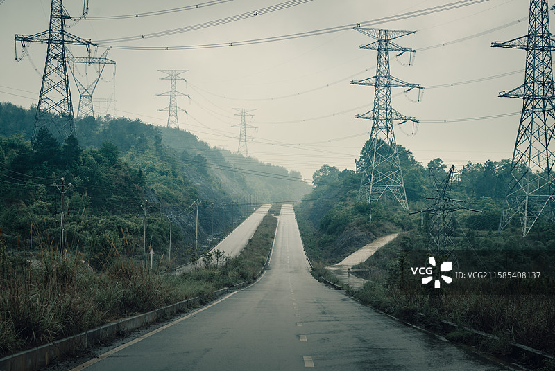 雨雾中的户外公路和远方的电力铁塔图片素材