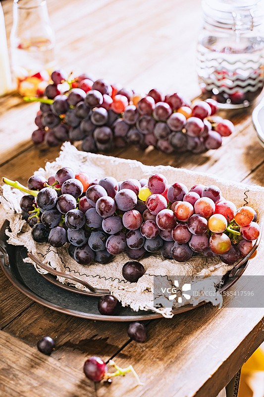 暗调静物美食摄影影棚拍摄高视角盘子里的水果葡萄特写，展现了自然物品的清新美好和健康的生活方式图片素材
