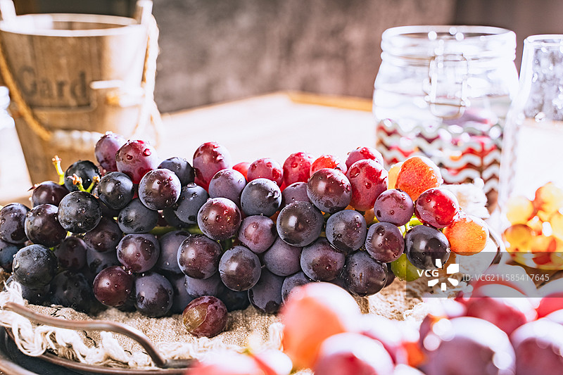 暗调静物美食摄影影棚拍摄正面视角盘子里的水果葡萄特写，展现了自然物品的清新美好和健康的生活方式图片素材