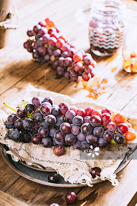 暗调静物美食摄影影棚拍摄高视角盘子里的水果葡萄特写，展现了自然物品的清新美好和健康的生活方式图片素材