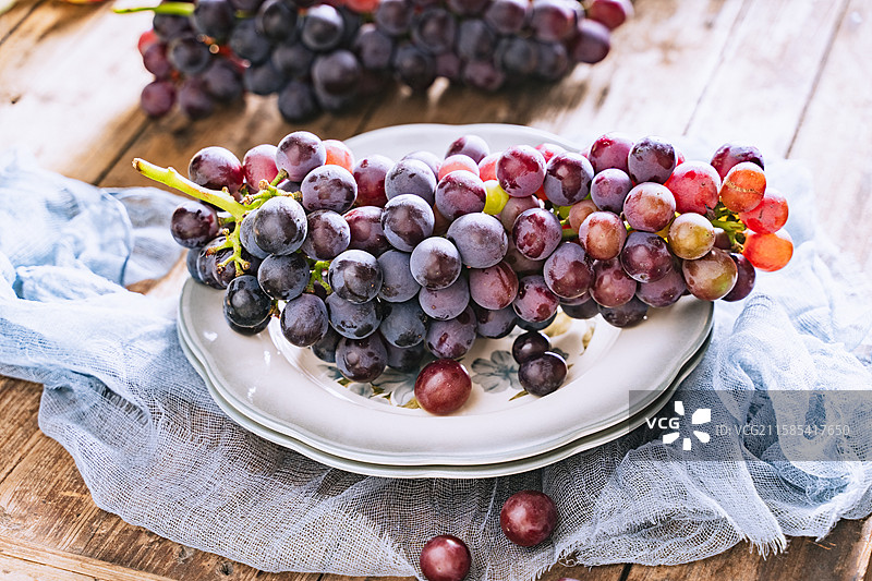 暗调静物美食摄影影棚拍摄高视角盘子里的水果葡萄特写，展现了自然物品的清新美好和健康的生活方式图片素材
