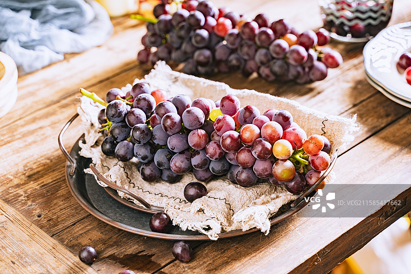 暗调静物美食摄影影棚拍摄高视角盘子里的水果葡萄特写，展现了自然物品的清新美好和健康的生活方式图片素材