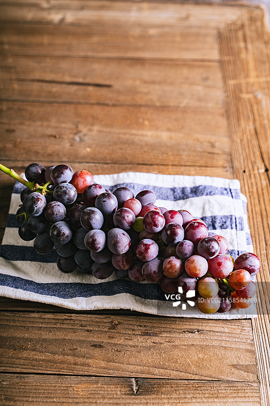 暗调静物美食摄影影棚拍摄高视角盘子里的水果葡萄特写，展现了自然物品的清新美好和健康的生活方式图片素材