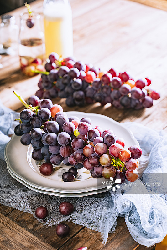 暗调静物美食摄影影棚拍摄高视角盘子里的水果葡萄特写，展现了自然物品的清新美好和健康的生活方式图片素材