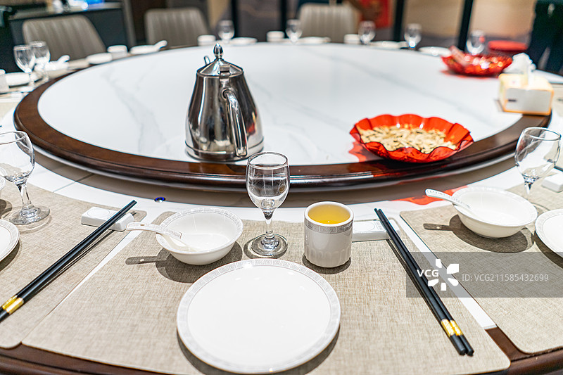 中国餐饮行业，空的餐桌拍摄主题，中国传统木制圆桌上的透明玻璃和餐具，室内无人图像摄影图片素材