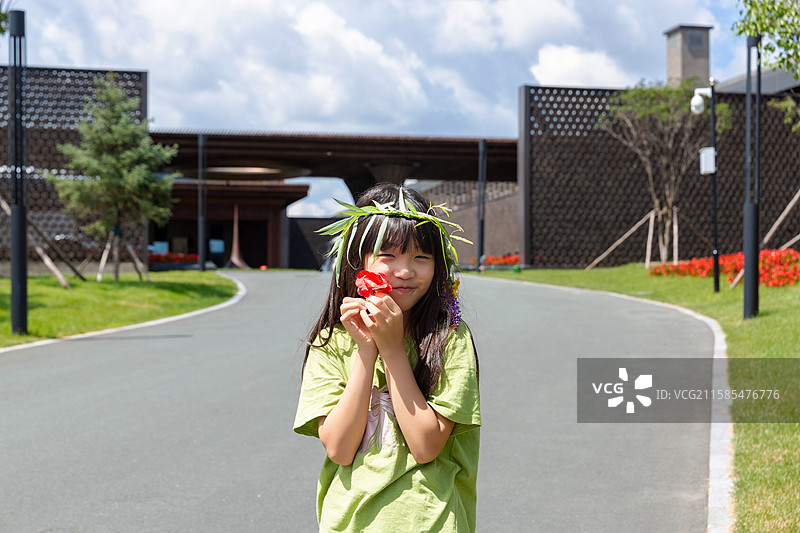 小女孩手持红花展露笑颜图片素材