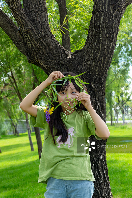 假期旅游在户外头戴柳条花环的中小女孩图片素材