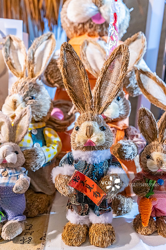 中国传统文化拍摄主题，书桌上摆放着各种卡通布料稻草制作的玩具玩偶兔子，室内无人图像摄影图片素材