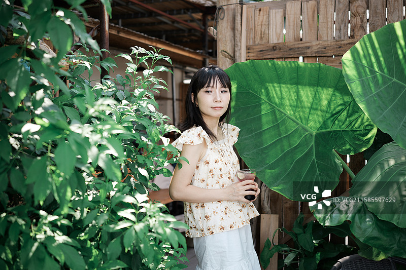 在绿植主题咖啡馆的年轻女性图片素材