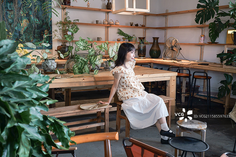 在绿植主题咖啡馆的年轻女性图片素材