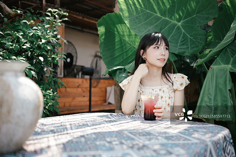 在绿植主题咖啡馆的年轻女性图片素材