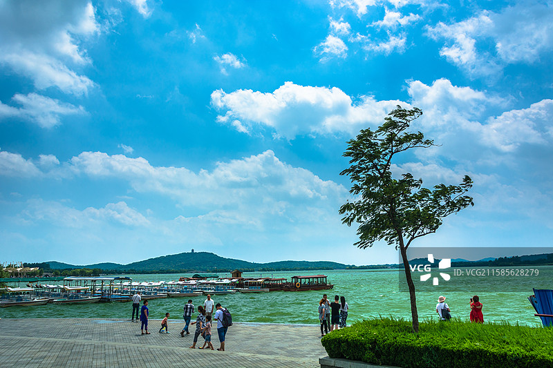湖畔漫步的人们与蓝天白云图片素材