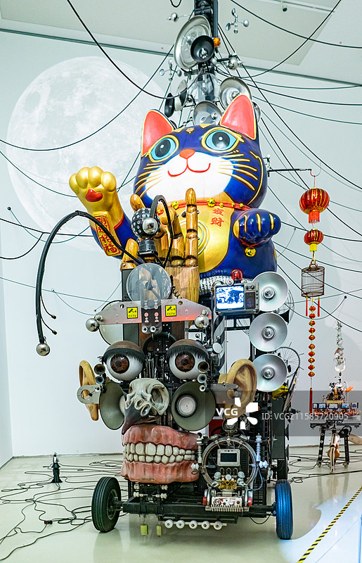 中国山东济南美术馆博物馆双年展，用废品垃圾材料制作组装焊接的招财猫机械装置艺术，室内人图像摄影图片素材
