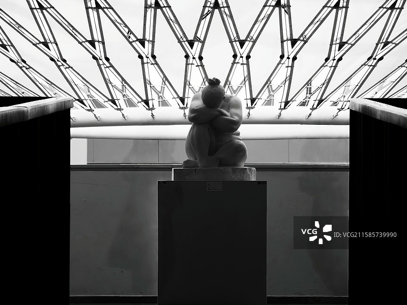 在空间的几何秩序里，雕塑以蜷缩之姿，拥抱自身。图片素材