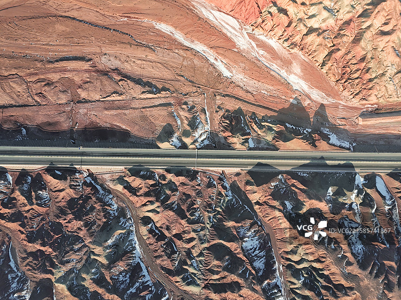 甘肃张掖甘州区丹霞地貌穿越红色峡谷的公路图片素材