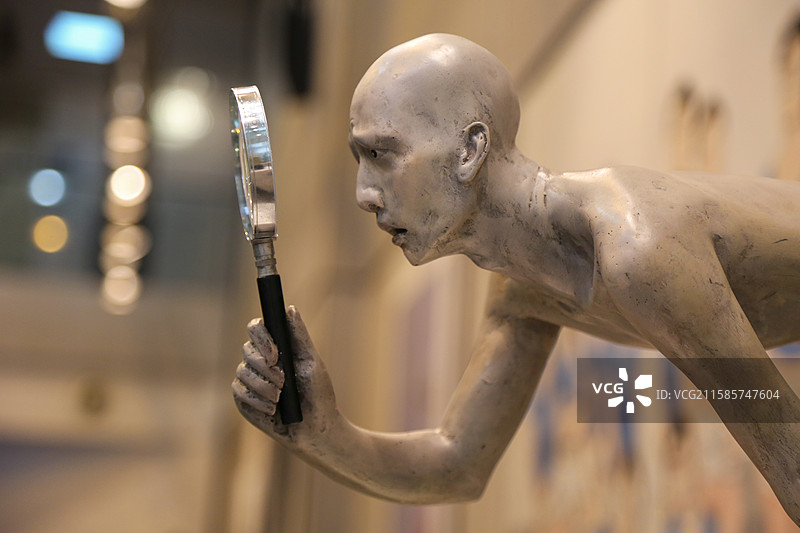 拿放大镜仔细观察的人的雕塑图片素材