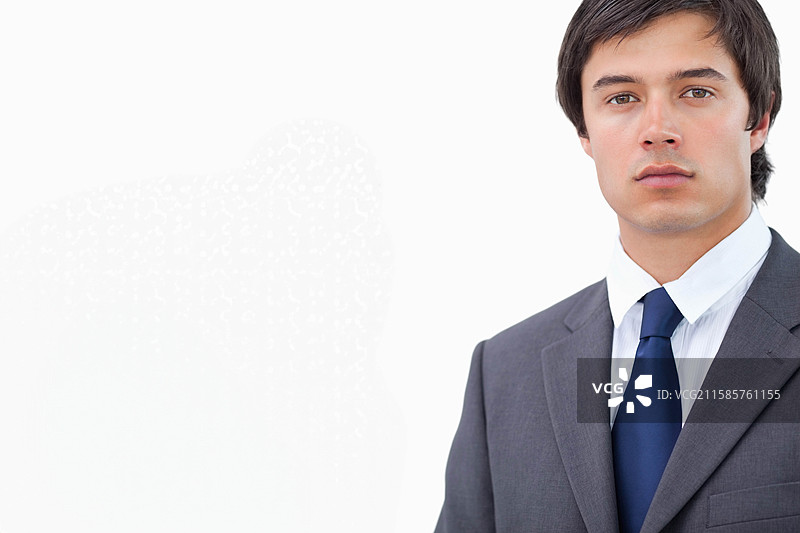 穿着灰色西装、白色衬衫和海军蓝领带的男士站在摄影工作室，留有空白空间图片素材