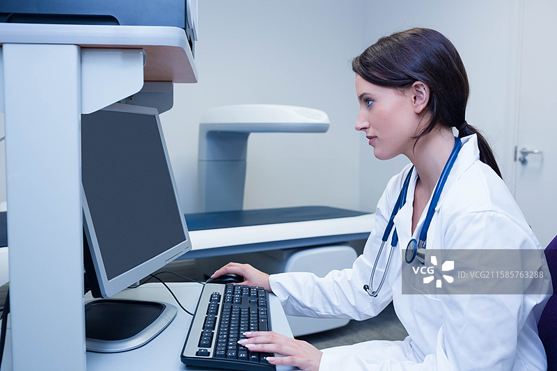 医疗成像设备在明亮的临床房间内的桌面监视器和键盘旁待命图片素材