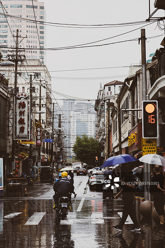雨天城市街道行人电动车与招牌图片素材
