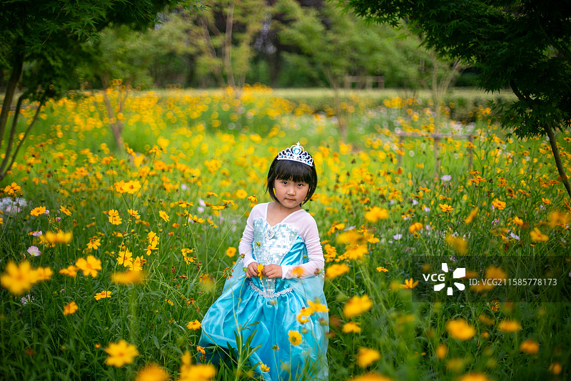 可爱的女孩站在花丛中的肖像图片素材