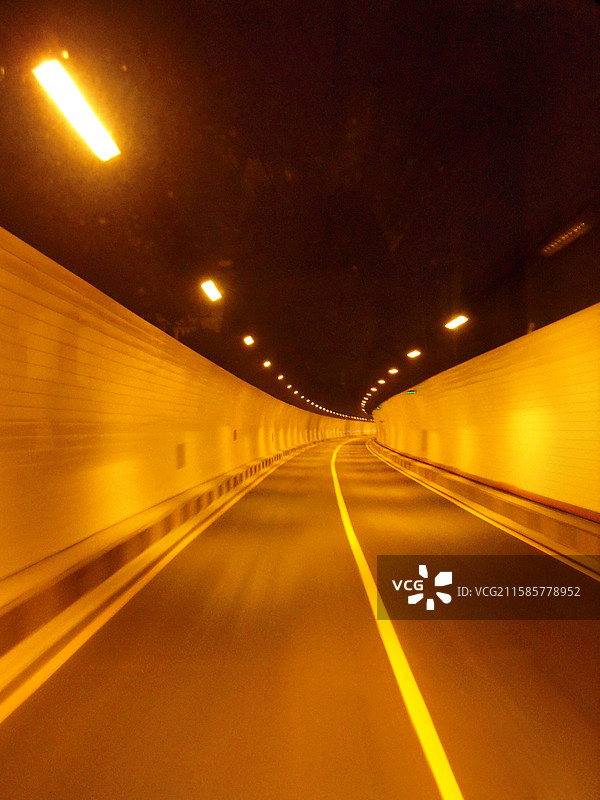 幽暗隧道里昏黄的灯光下 向前的路图片素材