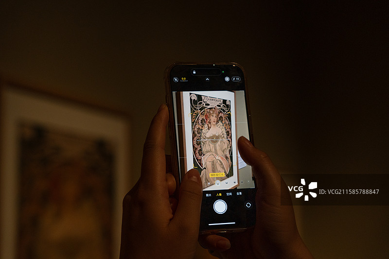 深圳南山博物馆参观人群手机中的穆夏的作品图片素材