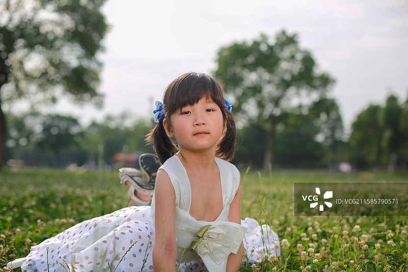 可爱的小女孩在草地上玩耍图片素材