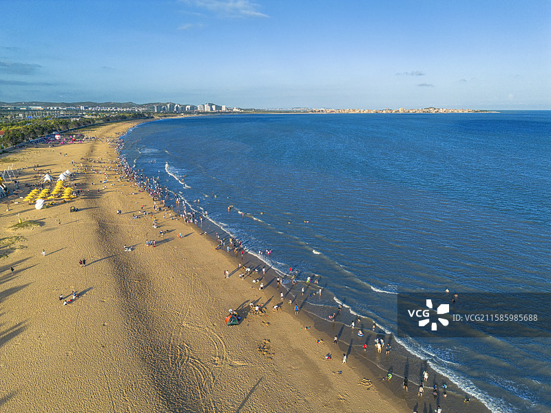 夏日傍晚的泉州惠安玉沙湾沙滩海边游客在海岸边嬉戏游玩图片素材